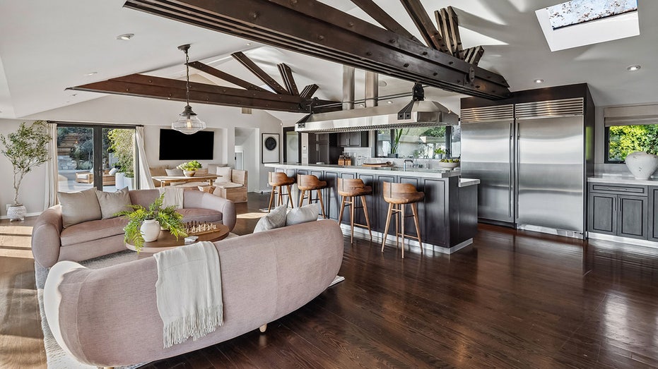 The kitchen also features a breakfast nook with a large flat-screen TV hanging over it.