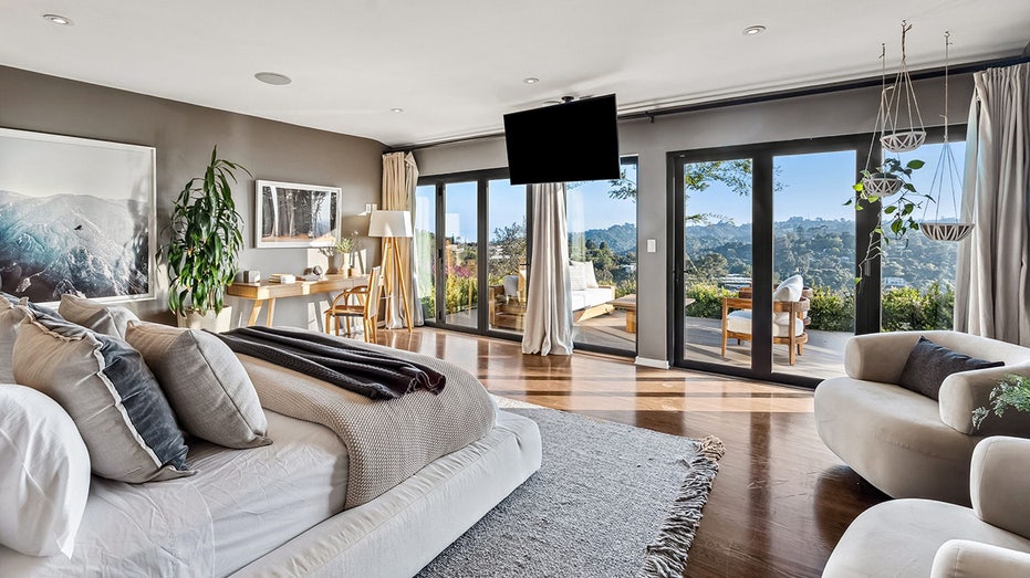 The primary bedroom features floor-to-ceiling glass doors leading to a private outdoor terrace.