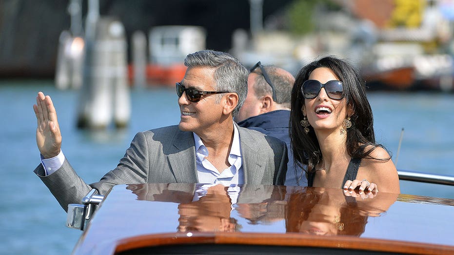 US actor George Clooney ( L) and his Lebanon-born British fiancee Amal Alamuddin take a taxiboat upon their arrival in Venice on September 26, 2014, on the eve of their wedding. AFP PHOTO / ANDREAS SOLARO ( ANDREAS SOLARO/AFP via Getty Images)