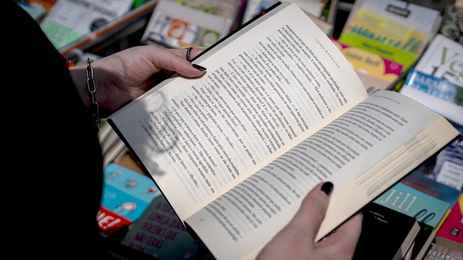 Woman holds book at fair in Portugal