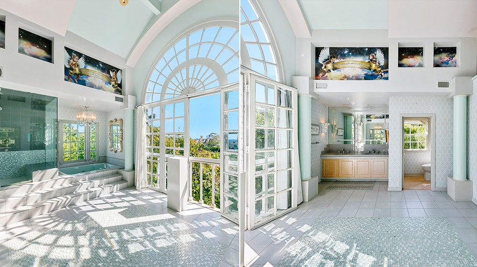 The ensuite bathroom features a large window with views of the city, as well as a soaking tub and shower.