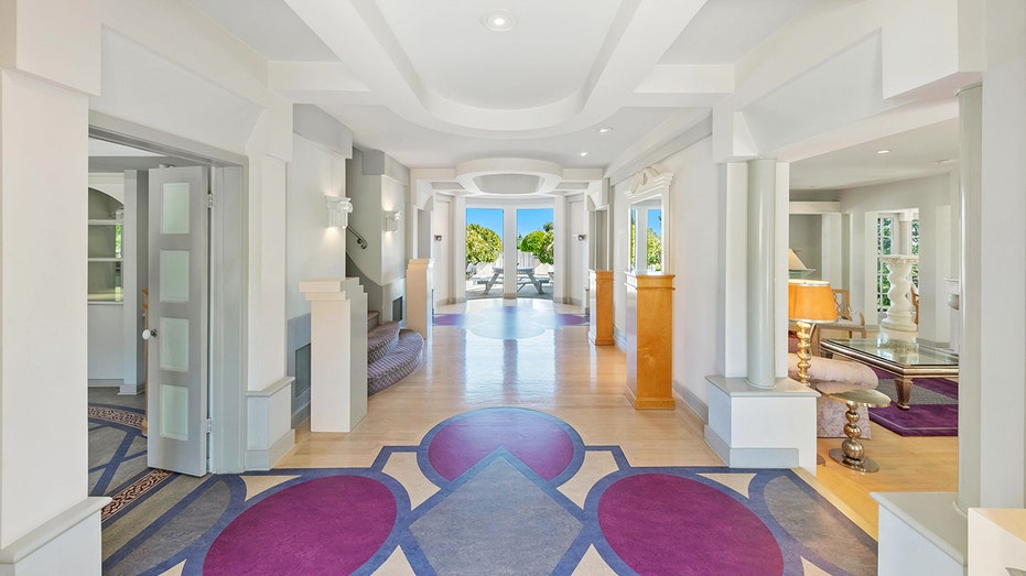 The entryway features custom purple and blue flooring.