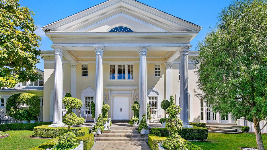 A pathway leads to the stately main house with Corinthian columns.