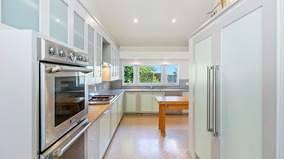 The kitchen features a double oven and a window above the sink.