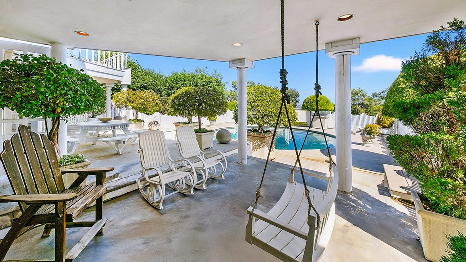 The backyard features a covered porch with a swing.