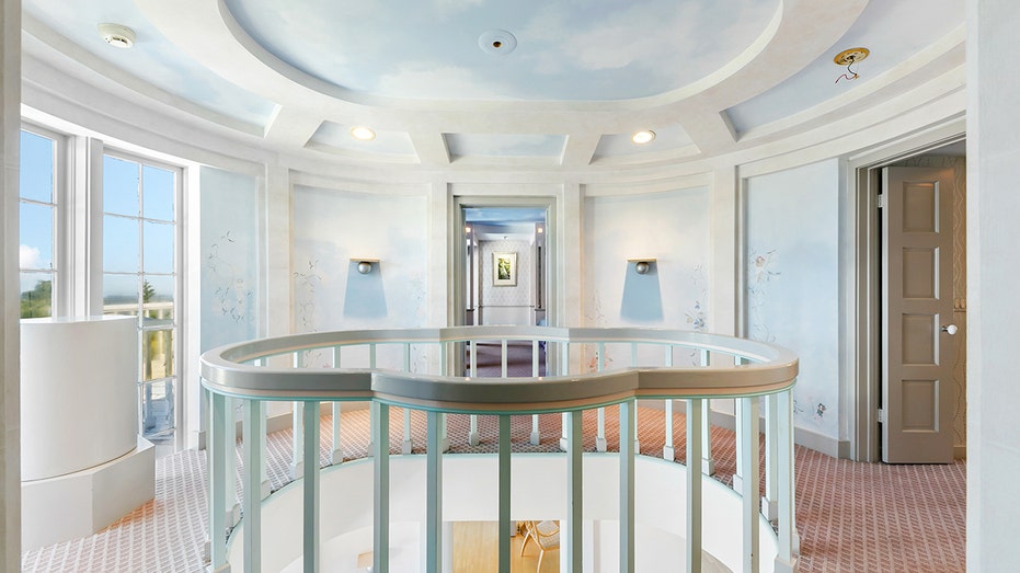 The staircase leads to the upper level with ceilings and walls painted to look like the sky.