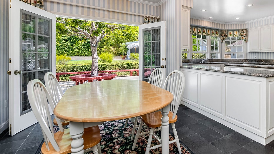 The kitchen also includes an informal dining space with doors leading to the backyard.