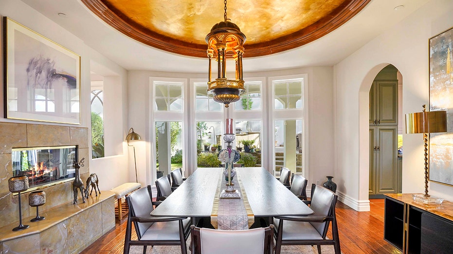 The dining room features a gold painted domed ceiling and a fireplace.