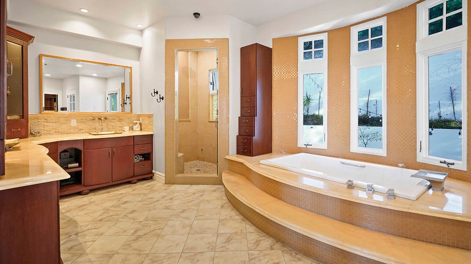 The ensuite bathroom features a bathtub and a standing shower.