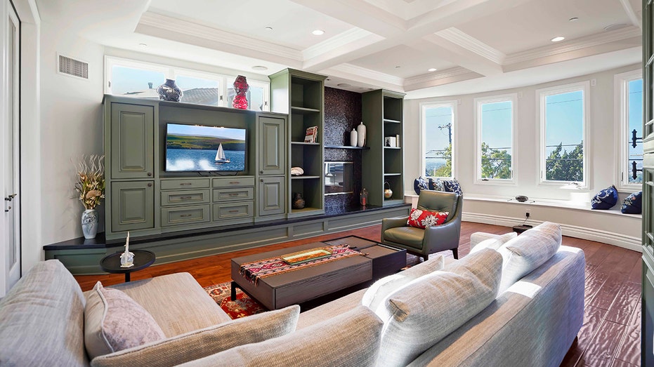 The family room features a large green entertainment system and a bay window.