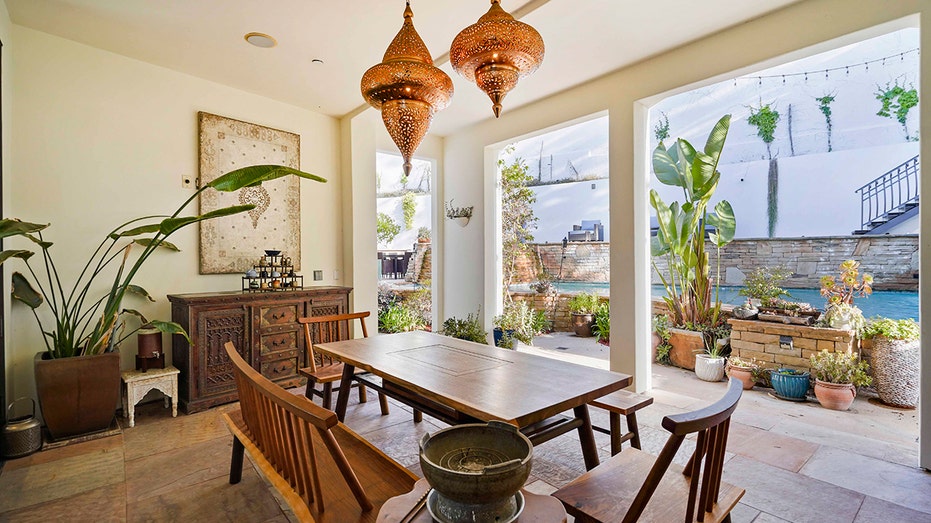 The backyard features an outdoor dining area with unique light fixtures.