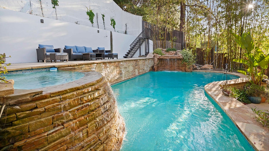 The backyard also includes a large swimming pool and outdoor seating area.
