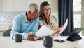 An older couple is sitting at their kitchen table reviewing financial documents. - Fox News