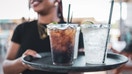 A server walks a tray of sodas to a table. - Fox Business News