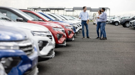 A couple talks with a car dealer after they purchased a new vehicle. - Fox Business News