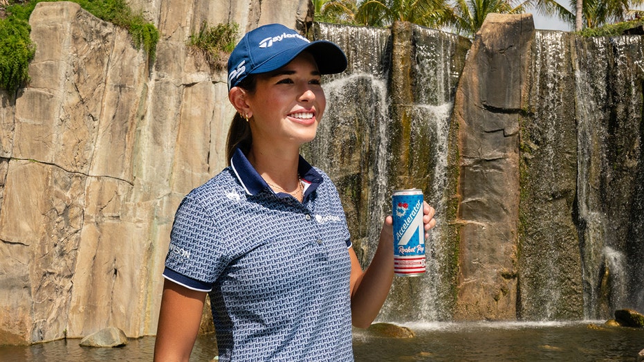 Kai Trump smiles with Accelerator drink