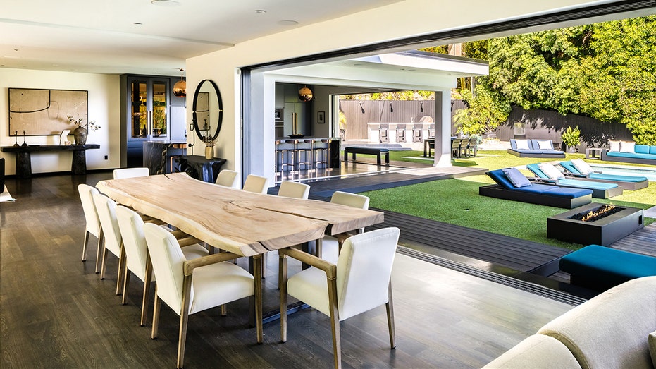The home features floor-to-ceiling sliding glass doors allowing for seamless indoor/outdoor living.
