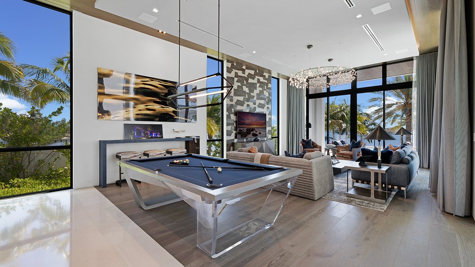 The billiards room is attached to another sitting room with large windows.