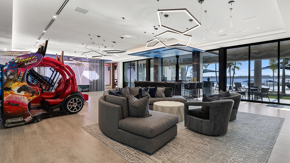 The game room features arcade games and another seating area.