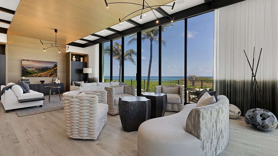 A seating area with floor-to-ceiling windows and a wooden ceiling.