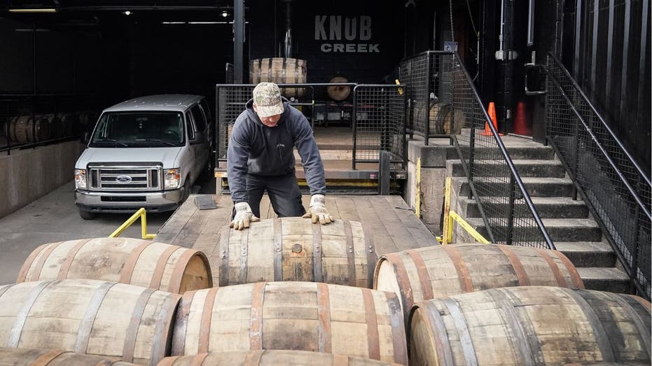 A worker at the Knob Creek distillery loads barrels of bourbon on a truck