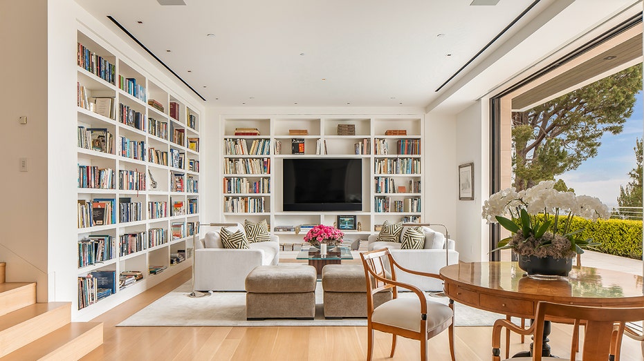 The family room includes a flat-screen TV and built-in bookshelves.