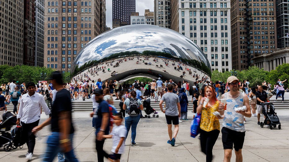 People walk around The Bean in Chicago