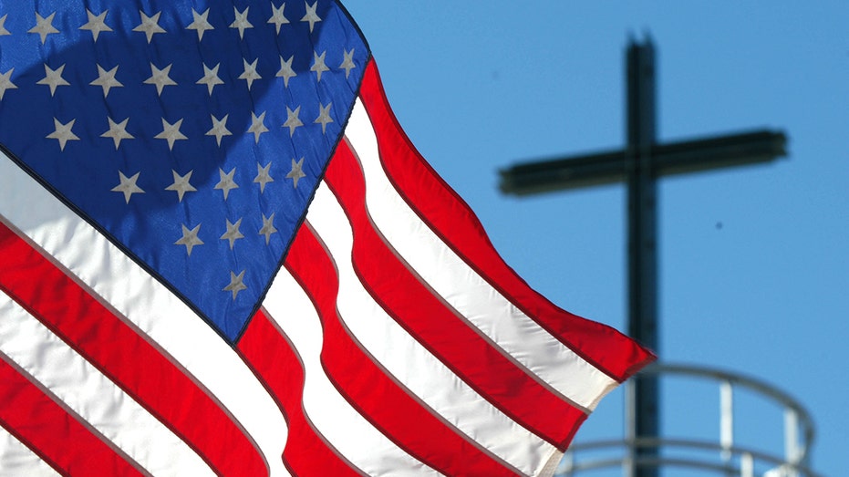 American flag with cross in background
