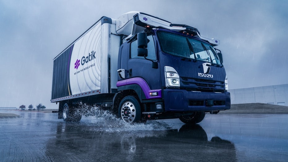 A truck driving over a puddle of water