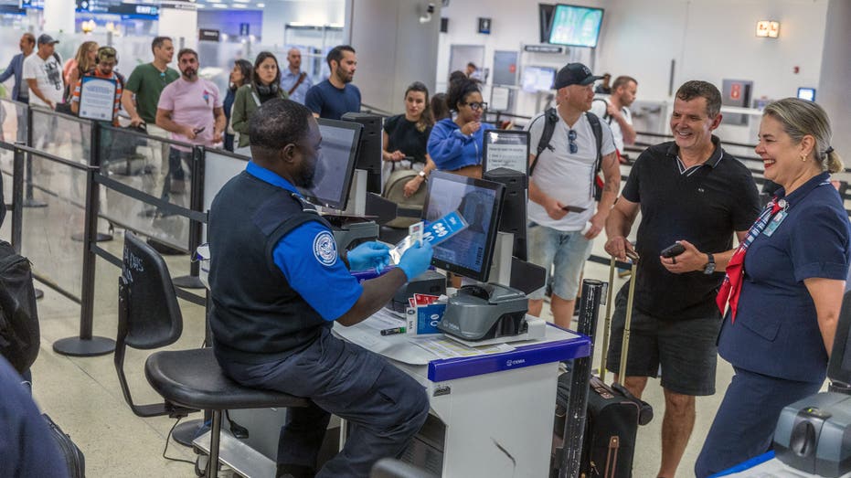 TSA agents verify passengers identities on a checkpoint at Miami International Airport as the Transportation Security Administration (TSA) announced the imminent implementation of its REAL ID enforcement measures at TSA checkpoints nationwide, Wednesday May 07, 2025.