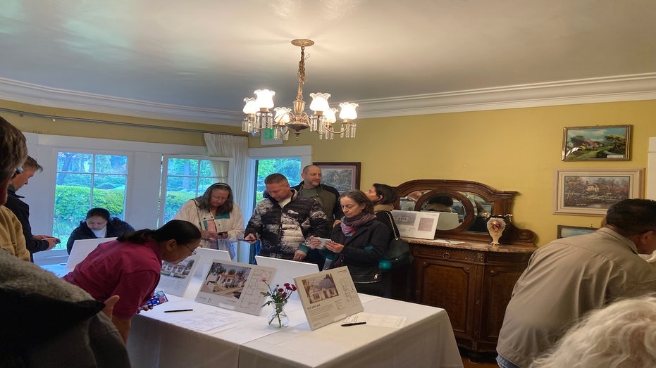 Fire victims looking at a blueprint of a home that was approved in advance.