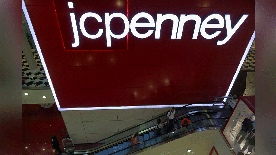 customers ride elevator next to large JCPenney sign