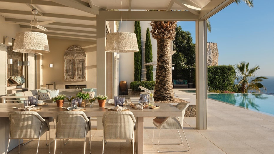 The backyard features an outdoor eating and lounging area with an outdoor fireplace.