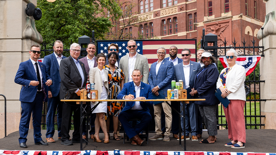 Mike Kehoe surrounded by people during signing of the American Beer Act
