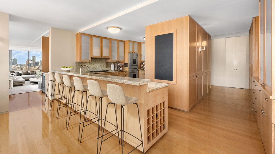 The kitchen features an eat-in bar and wooden cabinets.