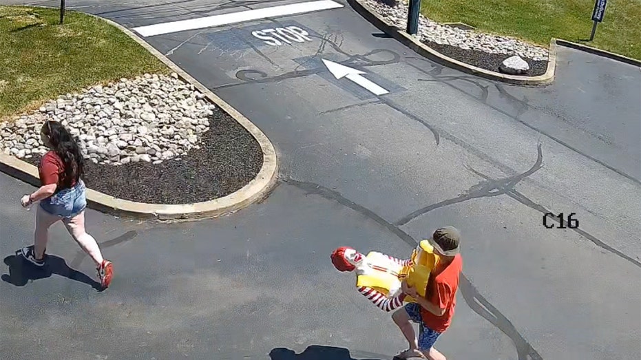 Individual carrying Ronald McDonald statue