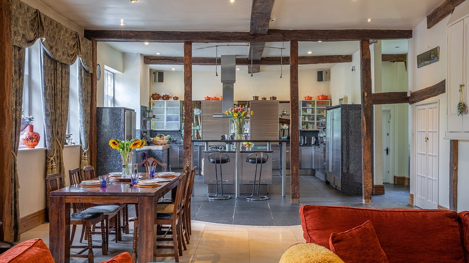 The kitchen is connected to a less formal dining area and a seating area.