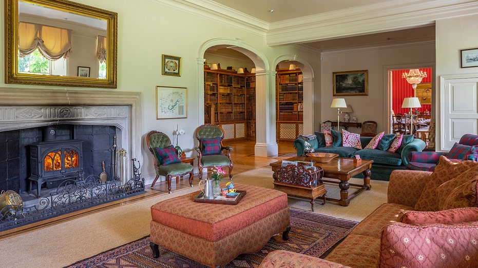 A living room with hardwood floors and a wood-burning fireplace.