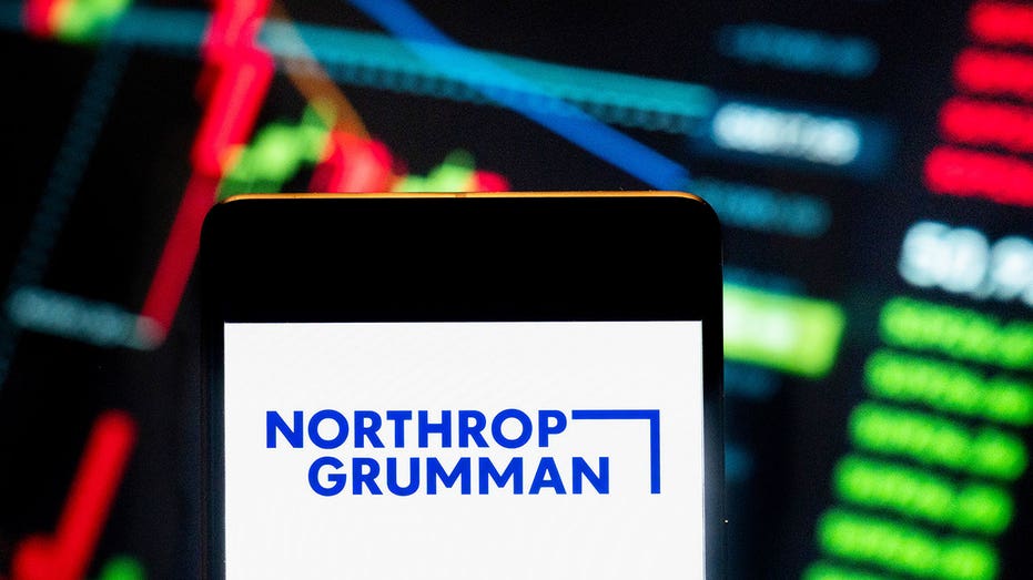 Hong Kong, China - 2024/06/21: In this photo illustration, the company's multinational aerospace and defense technology company Northrop Grumman (NYSE: NYOC) is displayed in a smartphone with an economic stock market schedule in the background. (Figures / Lightrocket via Budrul Chukrut / Sopa Images / Getty IMGS)