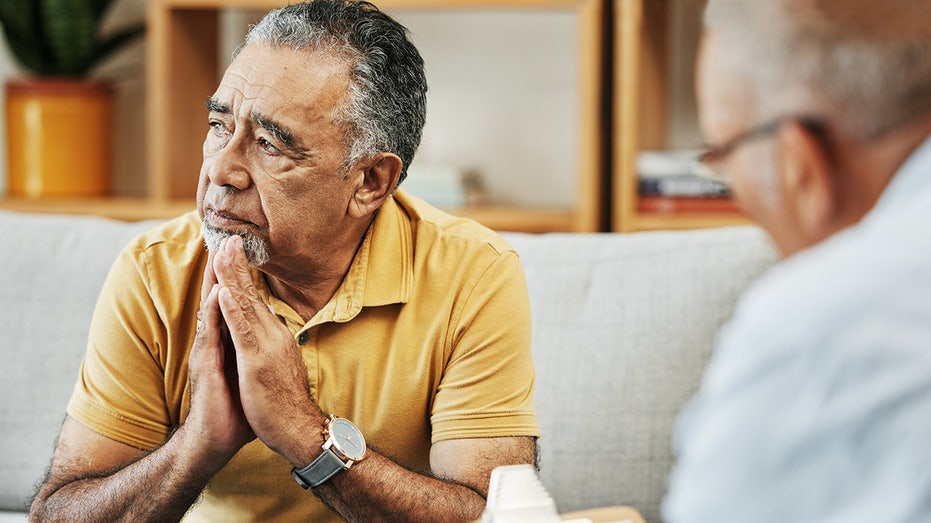 Elderly man talking to a psychologist at a mental health, psychology and therapy clinic for session. Psychological therapist with clipboard for counseling checklist with senior male patient in office