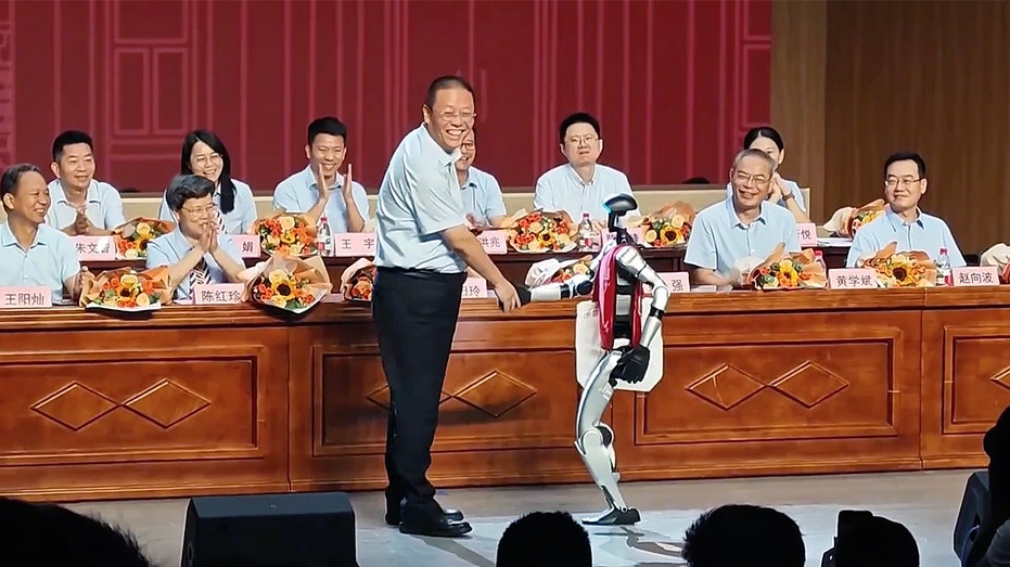 Humanoid robot shakes hands with teacher at Chinese high school graduation