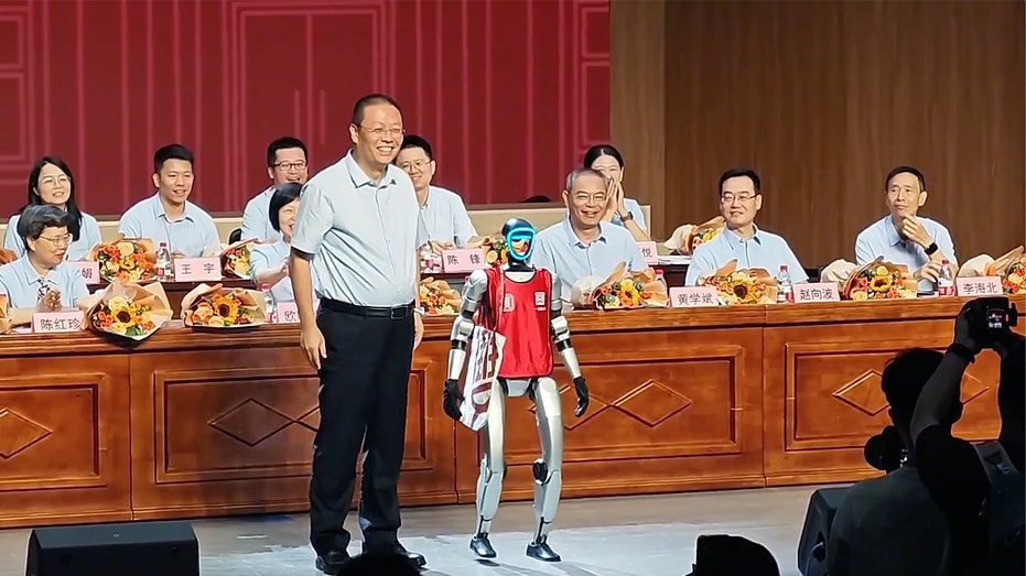 Robot stands with teacher after graduating at China school ceremony