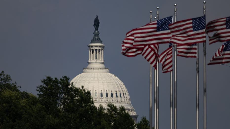 US Capitol with American flags flying nearby