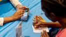 An attendee writes down information at a recruitment booth during the Best Hire Chicago Career Fair in Chicago, Illinois, US, on Thursday, Aug. 7, 2025.  - Fox Business News