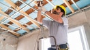 An electrician works inside a building installing wires. - Fox Business News