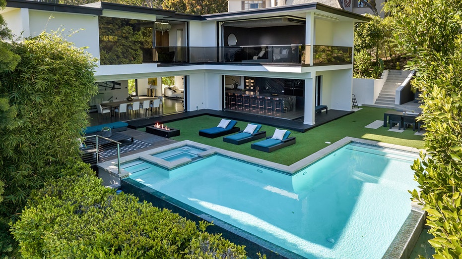 The backyard features a large swimming pool, a firepit and an outdoor kitchen.