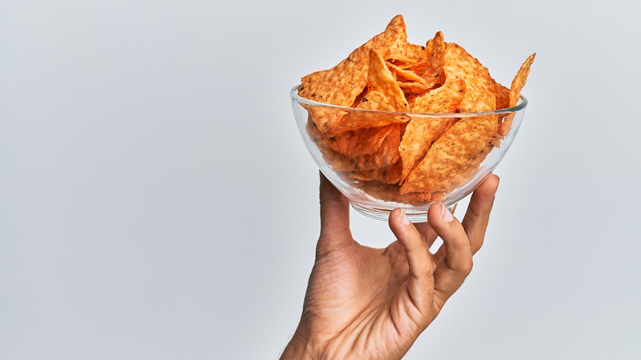 Hand holding bowl of chips