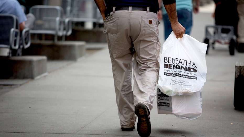 A customer carries shopping bags after exiting a Bed Bath & Beyond Inc. in New York in 2013.