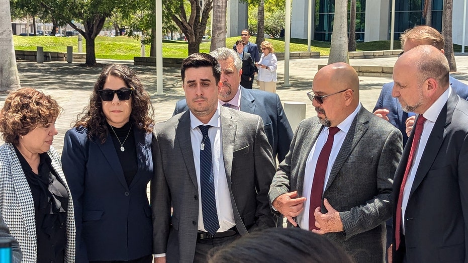 Dillon Angulo, center with tie, stands next to Neima Benavides, the sister of Dillon's girlfriend Naibel Benavides Leon, who was killed in the Florida Keys crash in 2019 near the Ocean Reef Club. Angulo's body was nearly shattered from the crash.