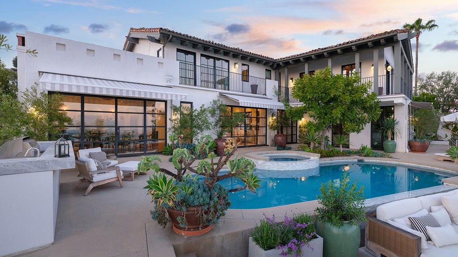 The backyard features an outdoor kitchen, fire pit and a large swimming pool.